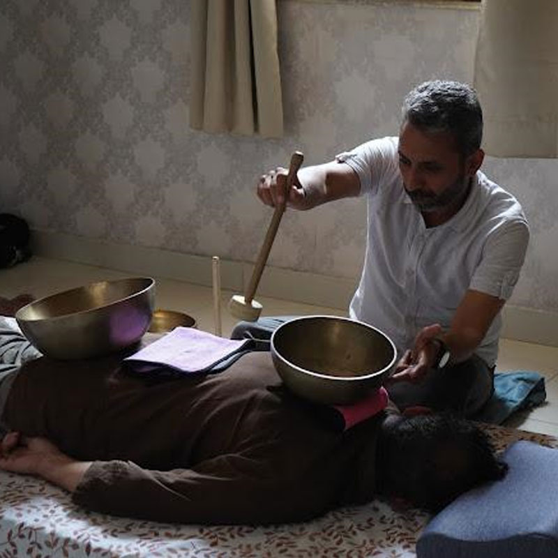 Sound healing practitioner conducting a singing bowl session