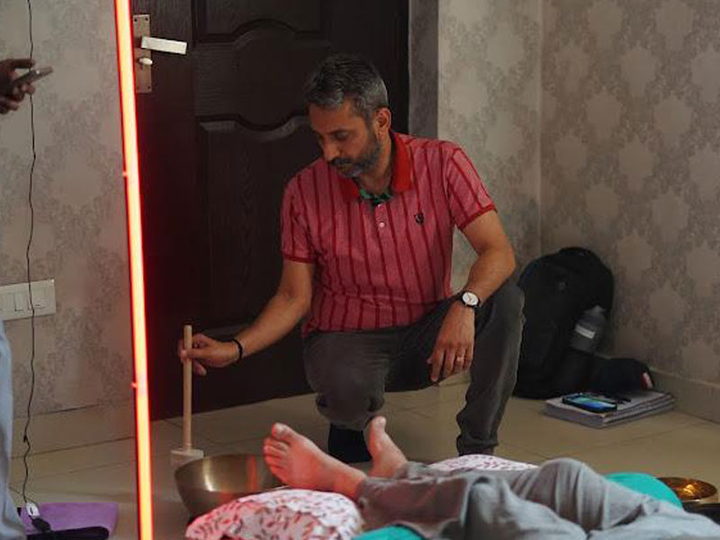 Sound healing practitioner using a singing bowl during a sound bath
