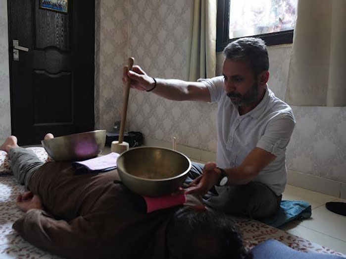 Sound healing practitioner conducting a singing bowl therapy session